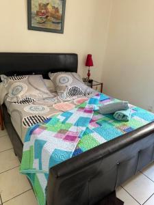 a bed with a quilt on it in a bedroom at Hotel baille castellane in Marseille