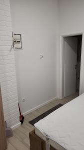 a white room with a bed and a door at Studio apartman Mara in Imotski