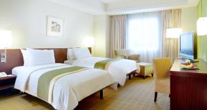 Un pat sau paturi într-o cameră la Java Paragon Hotel & Residences