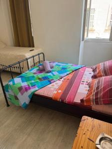 a bed with a colorful quilt on it in a room at Hotel baille castellane in Marseille +2 photos