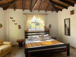 a bedroom with a bed with a window and a couch at Hotel Puerto Gaviota in Tonsupa +70 photos