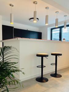 a kitchen with two stools in front of a counter at MY STAY - Smart Hotel in Mönchengladbach