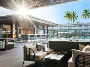 an outdoor patio with chairs and tables and a bar at Novotel Pontianak Convention Centre in Pontianak