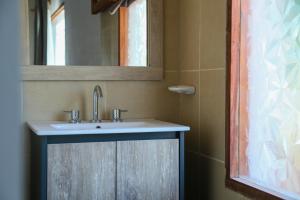 a bathroom with a sink and a mirror at Buenas Vibras Hostería Rural in Chicoana +122 photos