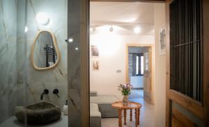a bathroom with a round mirror and a table at Penelope Suites With View Meteora in Kalabaka +104 photos