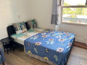 a small bedroom with a bed with a blue blanket at Logement Angèle in Malesherbes
