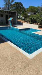 a swimming pool with blue water in a yard at Chalé Rosa - Top Country Ranch in Boituva