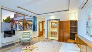 a living room with a television and a chair at Secluded Sea-View Family Escape Villa Bella 3 Lale in Üzümlü