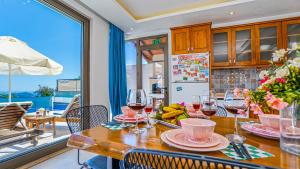 a kitchen with a table with glasses of wine at Secluded Sea-View Family Escape Villa Bella 3 Lale in Üzümlü