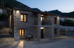 a stone house with a table in front of it at Penelope Suites With View Meteora in Kalabaka
