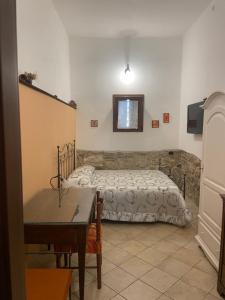 a bedroom with a bed and a table in it at La Via delle Rose in Alimena