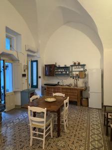 a kitchen with a table and chairs and a refrigerator at Ca Salentu in Galatone