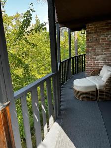 a porch with two chairs and a ottoman at The Private Perch in Nelson