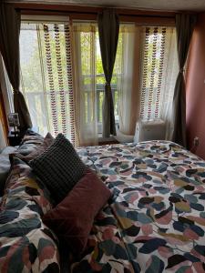 a bedroom with a bed and a window with curtains at The Private Perch in Nelson