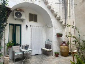 a patio with a table and chairs and a building at Ca Salentu in Galatone
