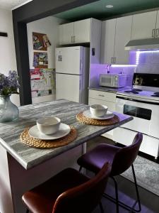 a kitchen with a counter with two plates and chairs at The Private Perch in Nelson