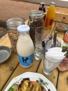 a table with a plate of food and a bottle of milk at Kârma Hôtel in Saint-Genis-les-Ollières