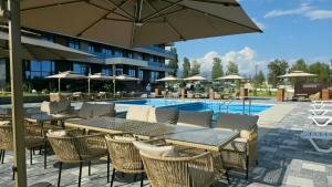 a patio with tables and chairs and a pool at Тынчтык Отель in Chon-Sary-Oy