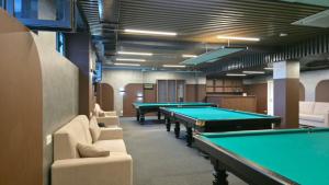 a room with pool tables and couches at Тынчтык Отель in Chon-Sary-Oy