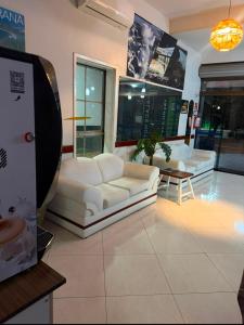 a living room with two white couches and a table at Visk Palace Hotel e Restaurante in Foz do Iguaçu