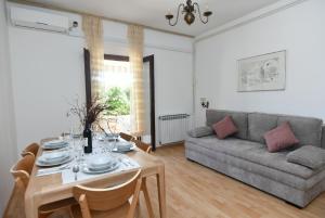 a living room with a table and a couch at Holiday Apartement Marija Supetar with private pool in Supetar