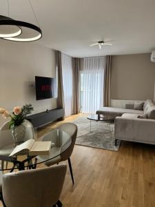 a living room with a couch and a table at NOVA Olimpia Residence - Free Garage in Sarajevo