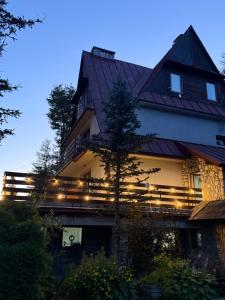 a house with lights on the side of it at Willa Wojciechówka in Kościelisko