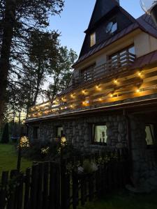 a house with lights on the side of it at Willa Wojciechówka in Kościelisko +1 photo