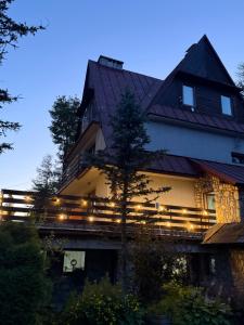 a large house with lights on the side of it at Willa Wojciechówka in Kościelisko