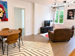 a living room with a table and a couch at Brick - Loft design avec parking privé in Saint-Désir +1 photo