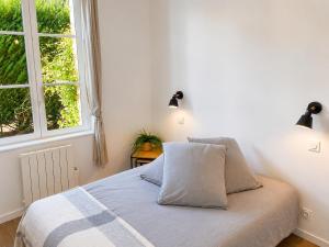 a bedroom with a bed with two lamps and a window at Brick - Loft design avec parking privé in Saint-Désir