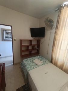 a small bedroom with a bed and a flat screen tv at ISIS HOTEl in Tumbes
