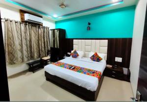 a bedroom with a large bed and a blue wall at Crown Hotel Aadoree - Near Mumbai Airport, BKC Visa Consultant , Jio Convention Centre in Mumbai