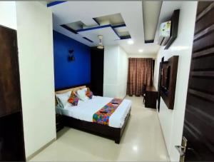 a bedroom with a bed and a blue wall at Crown Hotel Aadoree - Near Mumbai Airport, BKC Visa Consultant , Jio Convention Centre in Mumbai