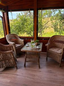 a screened in porch with wicker chairs and a table at Davidovic House in Amzići +11 photos
