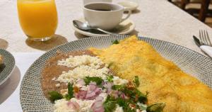 a plate of food on a table with a drink at La Posada Hotel y Suites in San Luis Potosí