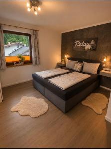 a bedroom with a bed with two rugs and a window at Appartement Wanneck in Biberwier