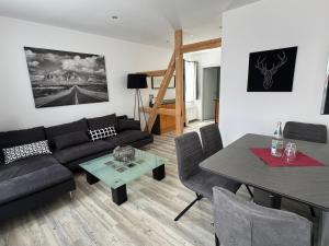 a living room with a black couch and a table at Charming Retreats Hasselfelde in Hasselfelde