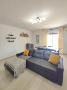 a living room with a blue couch with yellow pillows at Mivô - Alcochete Views & Comfort in Alcochete