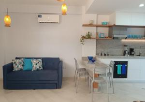 a living room with a blue couch and a kitchen at Yaque Breeze - Beach Apartament in El Yaque