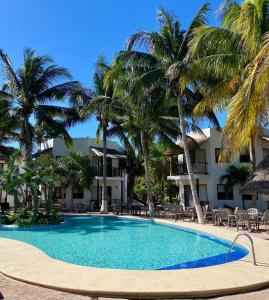 a swimming pool in front of a resort with palm trees at Tecnohotel Beach in San Benito