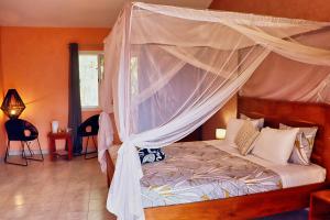 a bedroom with a bed with a canopy at Keur Noel in Ngaparou