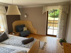 a bedroom with two beds and a couch and a window at FEWO Schulze Jonsdorf, Waldblick in Kurort Jonsdorf