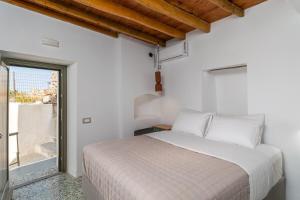 a white bedroom with a bed and a window at Astraea in Tripiti