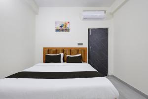 a bedroom with a white bed with black and white sheets at Hotel O VIP Inn in Bankipur