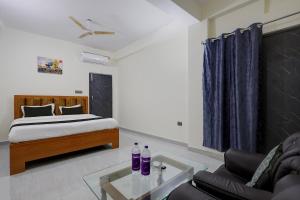 a bedroom with a bed and a couch and a glass table at Hotel O VIP Inn in Bankipur