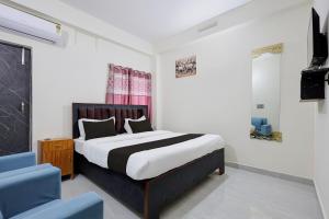 a bedroom with a bed and a blue chair at Hotel O VIP Inn in Bankipur +37 photos