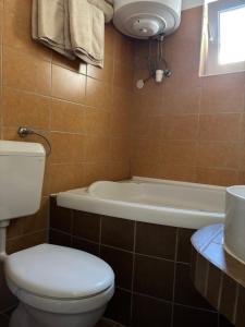 a bathroom with a toilet and a bath tub at Arborétum in Harkány +25 photos