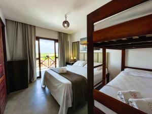 a bedroom with two bunk beds and a balcony at Villa do Sol - Icaraí de Amontada in Icaraí