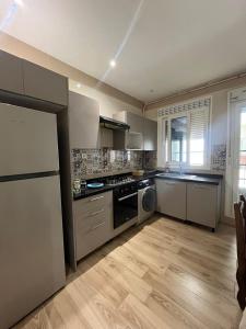 a kitchen with stainless steel appliances and wooden floors at Résidence Luna in Oran
